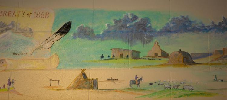 mural on school wall with horse and rider and pueblos