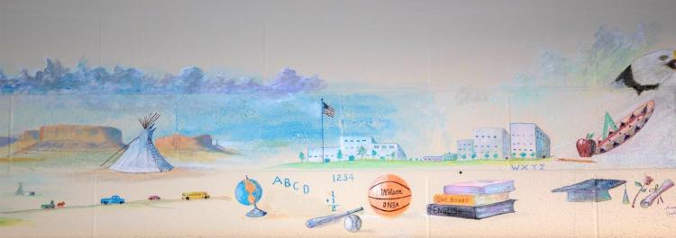 A colorful mural showing a Native American village with traditional homes and symbols of daily activities.